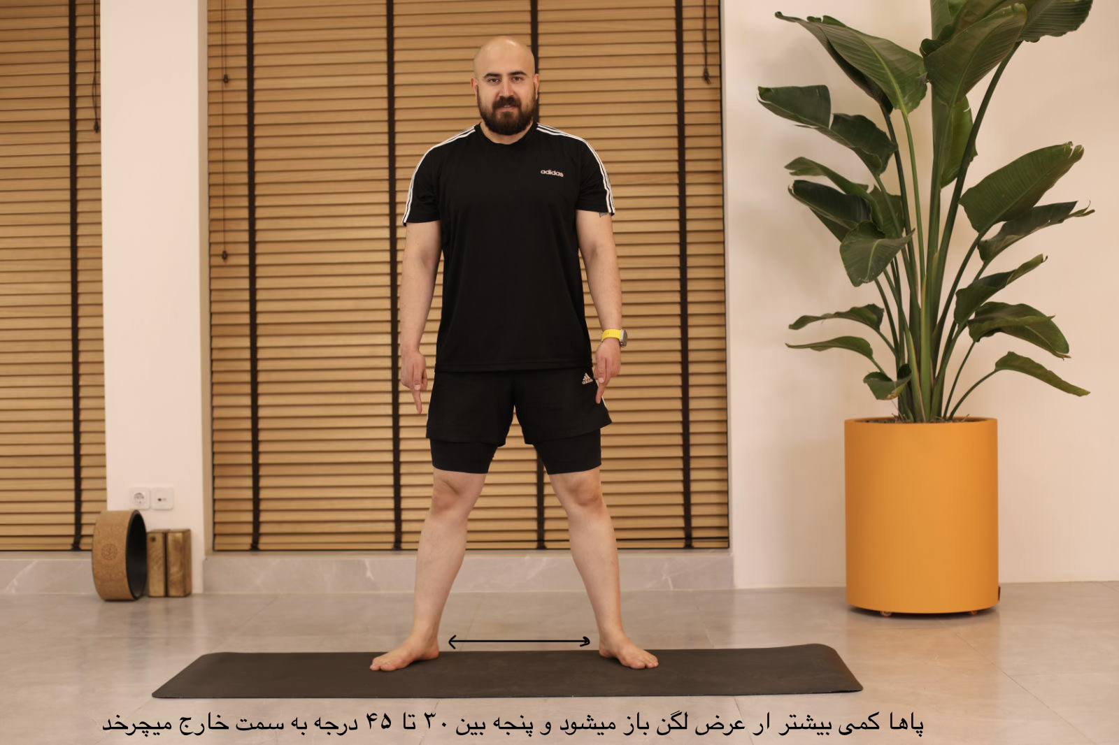 «شروع وضعیت مالاسانا؛ باز کردن پاها کمی بیشتر از عرض لگن و چرخاندن پنجه‌ها به بیرون»